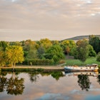 Boat on the Yonne river with reflections at sunset near Joigny in Burgundy, France.